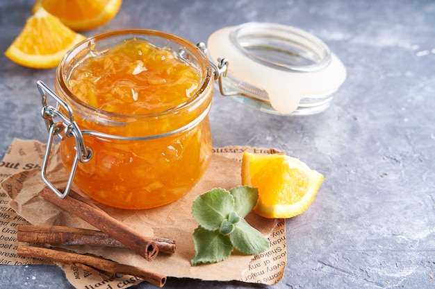 Homemade orange jam in jar on a gray table. Food background