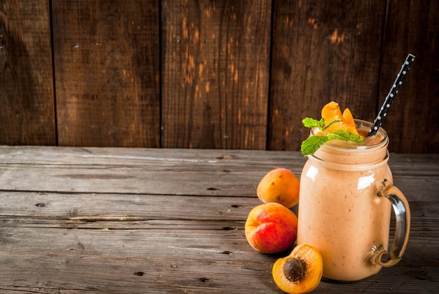 Homemade organic smoothie from yogurt and apricot. In Mason Jar, on a rustic old wooden table