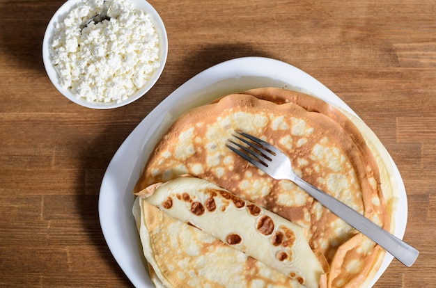 Homemade pancakes on a white plate with cottage cheese