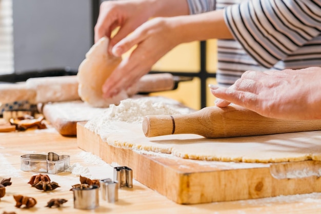 Homemade pastry Closeup of woman hands rolling dough in flour making gingerbread biscuits