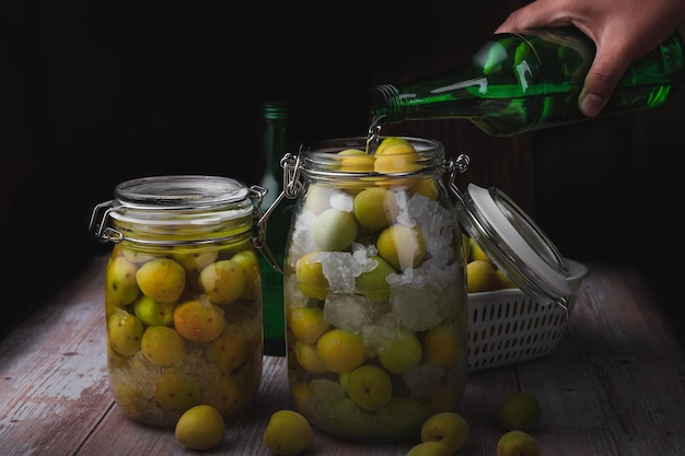 Homemade pickled plum with liquor and rock sugar in the glass bottle