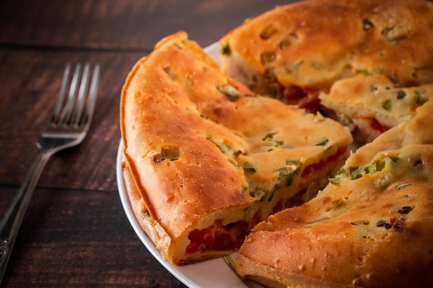 Homemade pie with chicken herbs and tomatoes on a plate