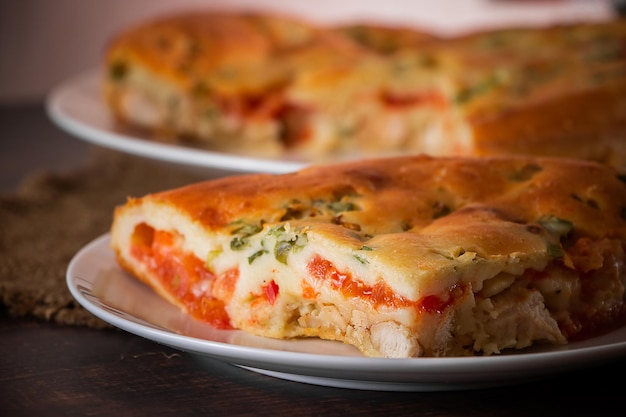 Homemade pie with chicken herbs and tomatoes on a plate