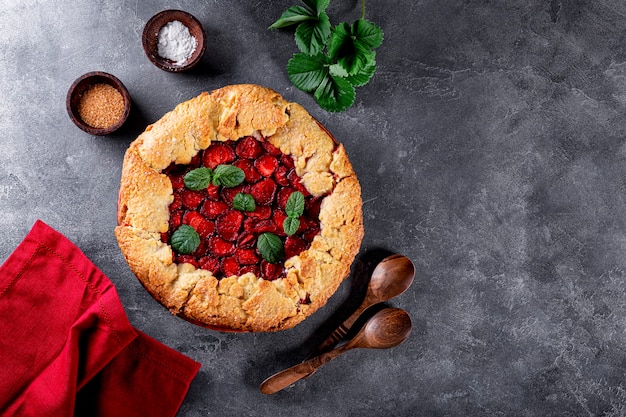 Homemade pie with strawberries on gray background top view summer pastries with berries photo with