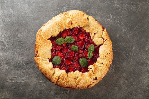 Homemade pie with strawberries on the grey background top view summer pastries with berries