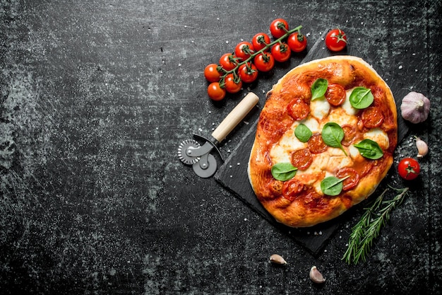 Homemade pizza with tomatoes on a branch and rosemary