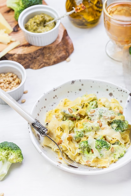 Homemade pumpkin pasta tagliatelle with broccoli and pesto in a creamy sauce