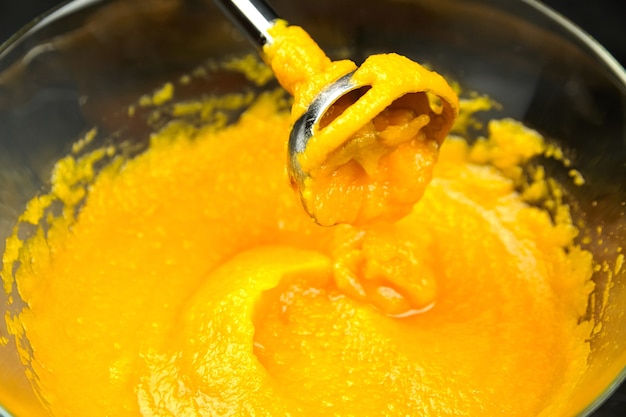 Homemade Pumpkin Puree. Hand Blender In Transparent Bowl On Black Background. Cooking Mashed Pumpkin, Healthy Vegetable Food