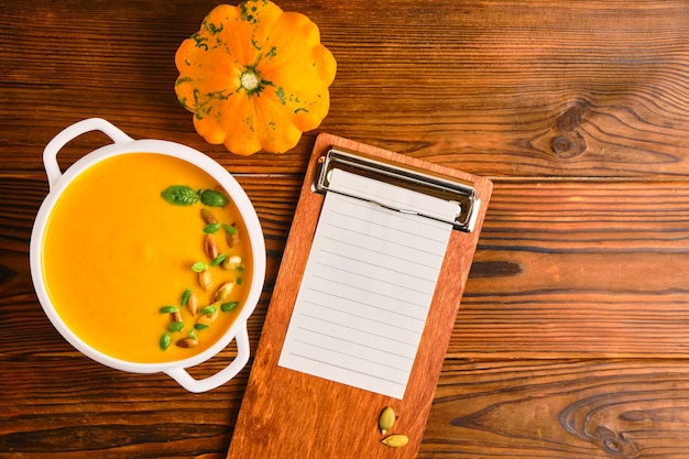 Homemade pumpkin soup with cream in a white bouillon dish