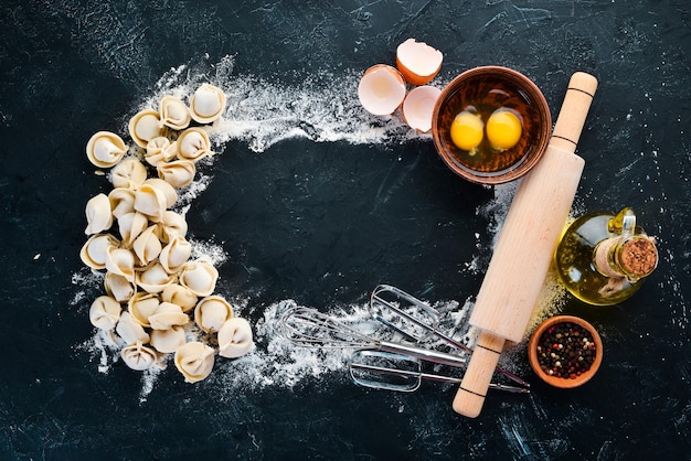 Homemade Ravioli Dumplings Flour eggs dough on a black background Top view Free copy space