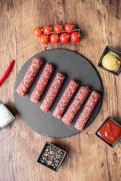 Homemade raw meat lula kebab sausages on a cutting board. wooden background.