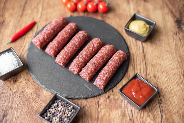 Homemade raw meat lula kebab sausages on a cutting board. wooden background.