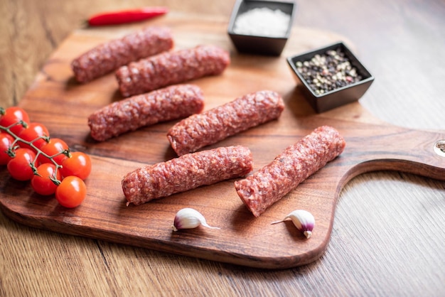 Homemade raw meat lula kebab sausages on a cutting board. wooden background.