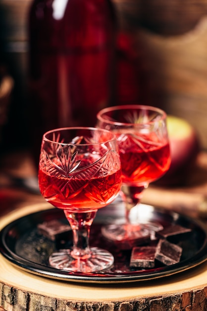 Homemade red currant nalivka and chocolate on metal tray