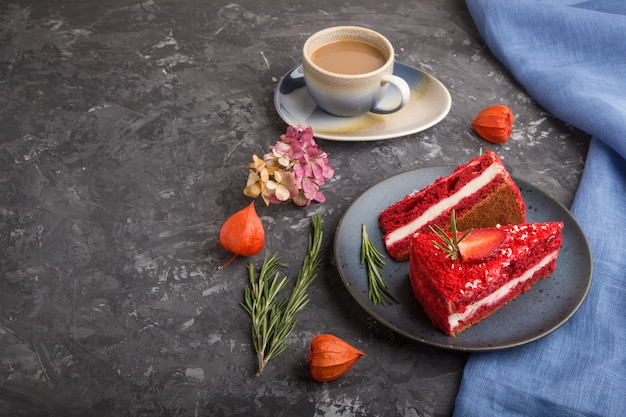 Homemade red velvet cake with milk cream and strawberry  with cup of coffee on a black concrete surface. side view, copy space.