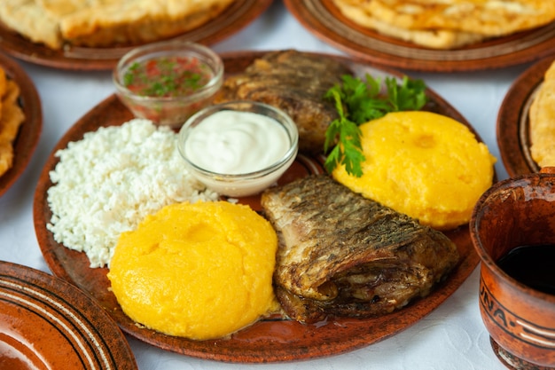 Homemade Romanian Food with grilled fish polenta pies vegetables with red win