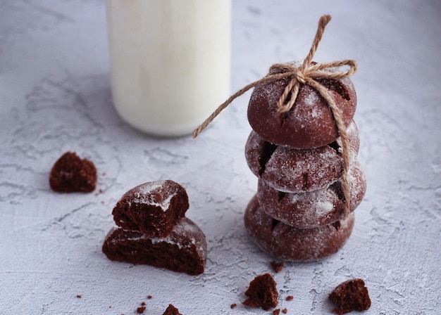 Homemade round gingerbread with cinnamon in powdered sugar with pieces of gingerbread and milk