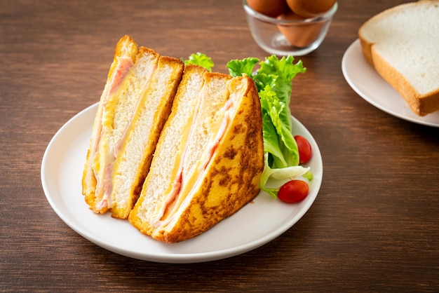 homemade sandwich ham cheese with salad on white plate