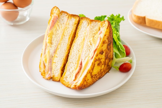 homemade sandwich ham cheese with salad on white plate