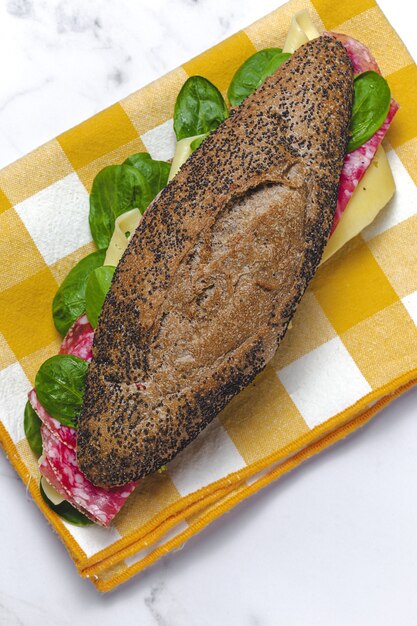 Homemade Sausage sandwich with lettuce and cheese with seed bread. Take away. Delivery food