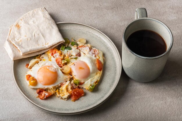 Homemade shakshuka, fried eggs, leek, bell pepper and  tomatoes  in a gray plate. Mediterranean cuis