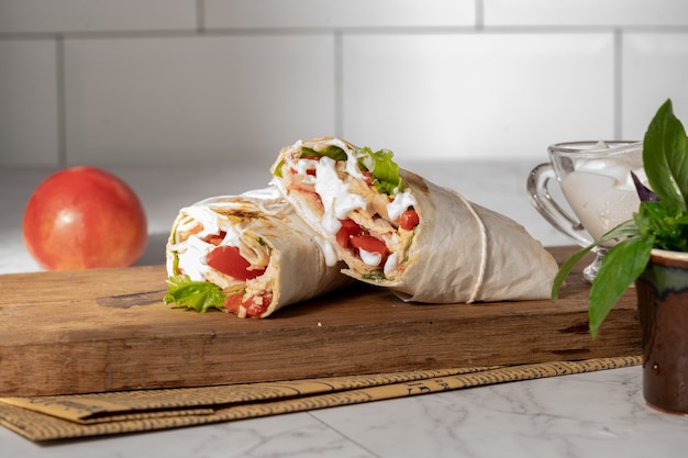 Homemade shawarma or burrito or chicken roll with vegetables and sauce