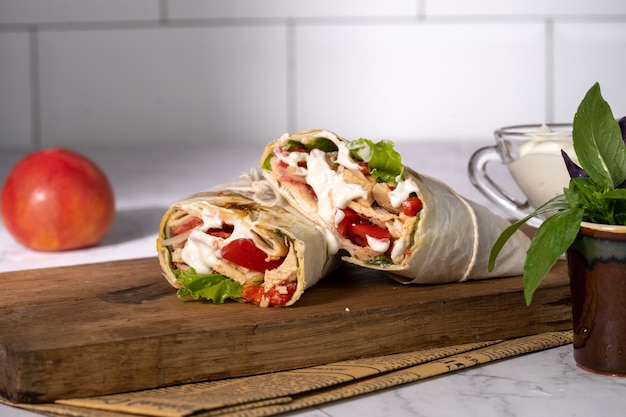 Homemade shawarma or burrito or chicken roll with vegetables and sauce