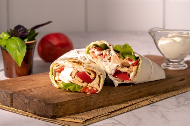 Homemade shawarma or burrito or chicken roll with vegetables and sauce