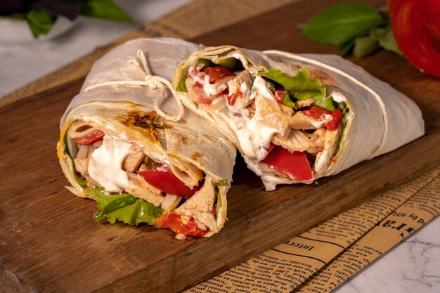 Homemade shawarma or burrito or chicken roll with vegetables and sauce