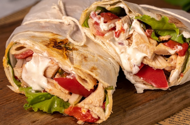 Homemade shawarma or burrito or chicken roll with vegetables and sauce