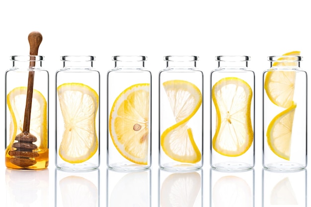 Homemade skin care lemon slice and lemon twist in glass bottles isolated on white background