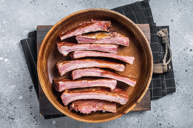 Homemade Smoked Barbecue Pork Ribs in wooden plate ready for eat Gray background Top view