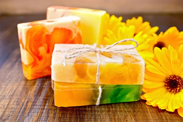 Homemade soap yellow marigold on a wooden boards background