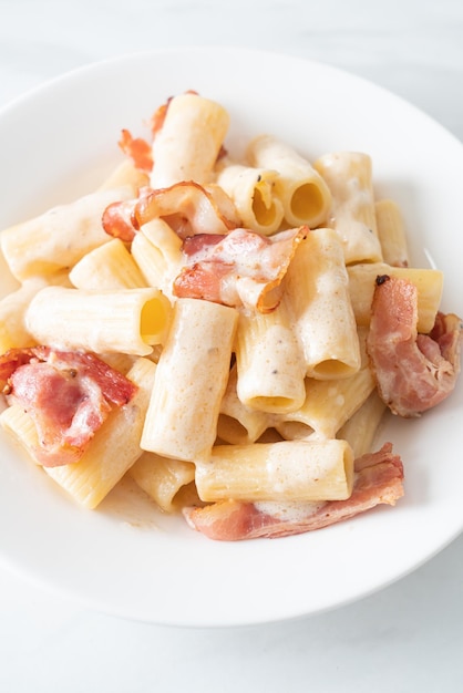 homemade spaghetti rigatoni pasta with white sauce and bacon - Italian food style