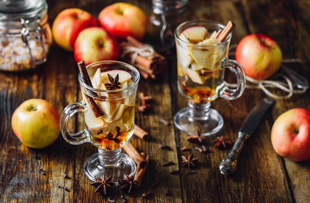 Homemade Spiced Beverage with Sliced Apples and Some Kitchen Herbs