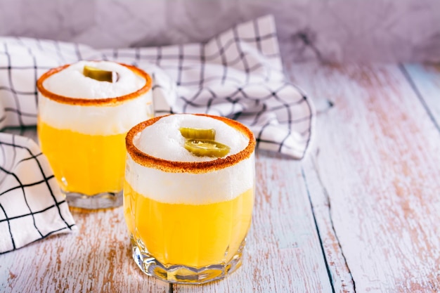 Homemade spicy cocktail with margarita egg white foam tagine and jalapeno peppers in glasses