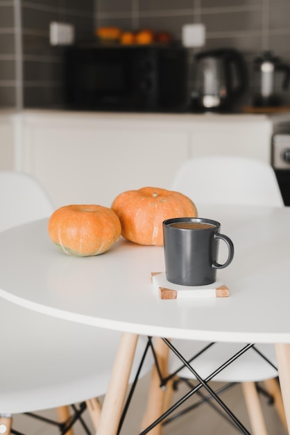 Homemade spicy coffee with cinnamon and pumpkin served on white dining table in the kitchen