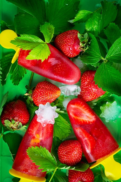 Homemade strawberry ice cream or popsicles ice strawberry leaves and berries