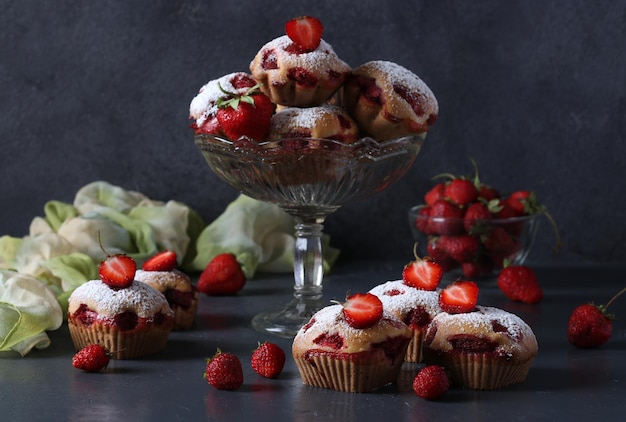 Homemade strawberry muffins sprinkled with powdered sugar Still life on a gray background