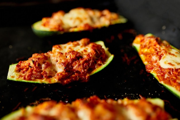 Homemade stuffed zucchini on black background