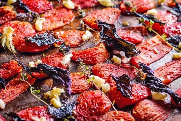 Homemade sun dried tomatoes with basil, garlic and spices on paper