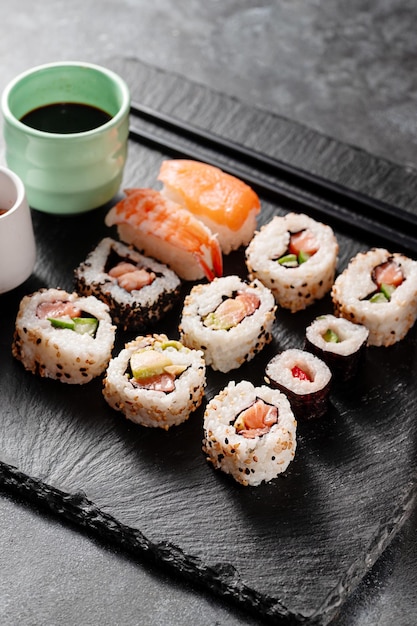 Homemade sushi rolls with salmon shrimp avocado Served with soy sauce and ginger