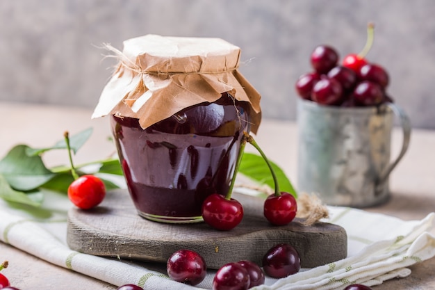 Homemade sweet and sour cherry jam with fresh cherries on the light table