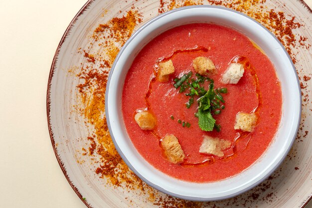 Homemade tomato soup with bread, mint and olive oil