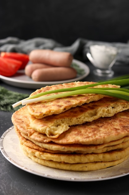 Homemade tortillas, located on a plate, sausages and tomatoes