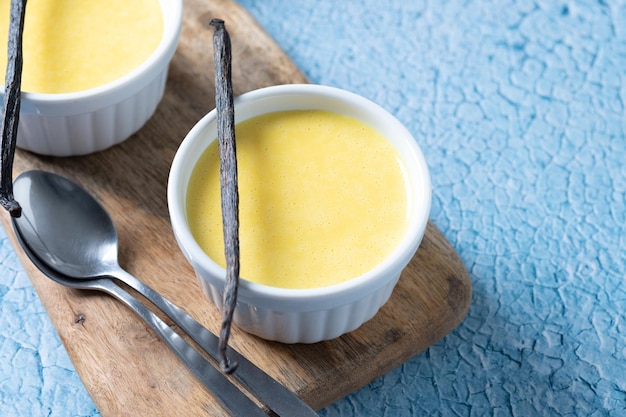 Homemade vanilla custard on blue background