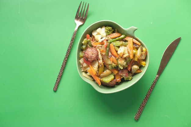 Homemade vegetable salad in a bowl on green desk