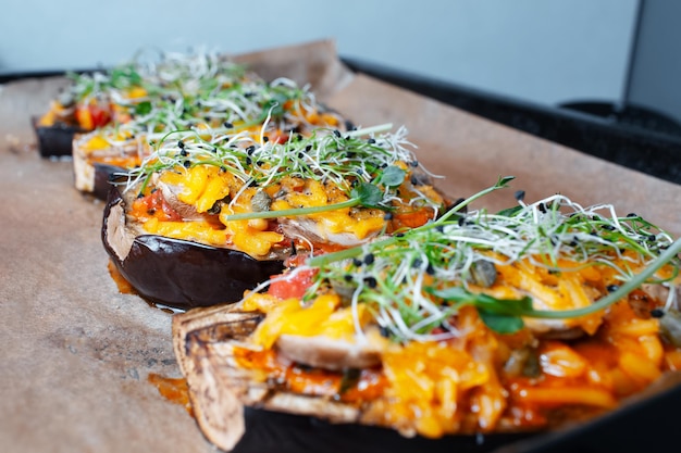 Homemade veggie food Eggplants boats stuffed with mushrooms and vegan cheddar