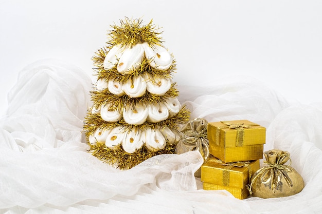 Homemade white Christmas tree with tinsel and box with gifts on white background chiffon