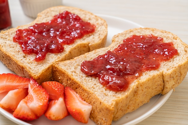 Homemade whole wheat bread with strawberry jam and fresh strawberry